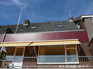 Totaalbeeld van ons huis met windmeter op de schoorsteen